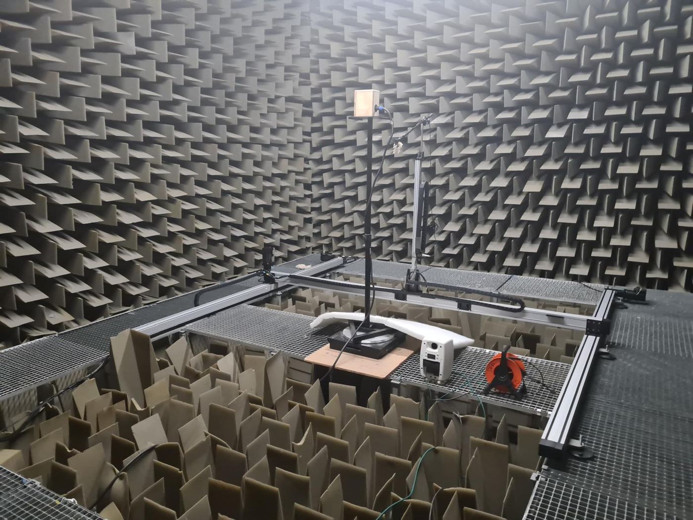 Cámara anecoica del laboratorio con altavoz, micrófono y sistema de barrido sobre una muestra